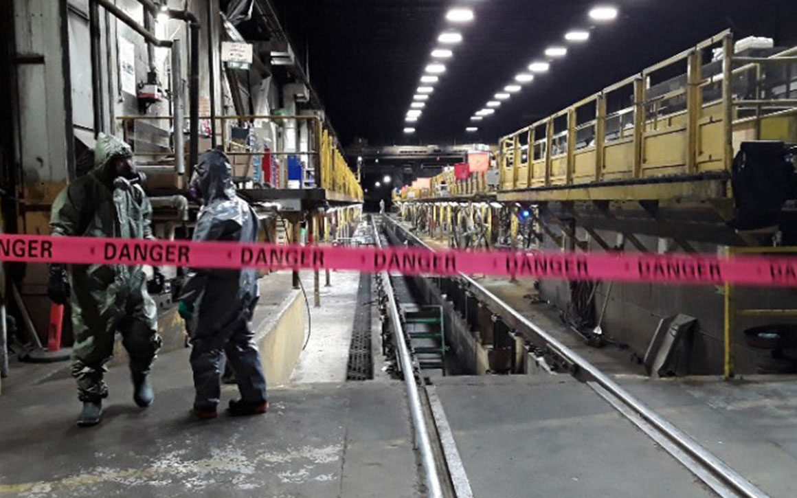 workers in hazmat suits walk a around quarantined facility